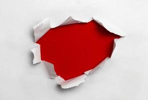 White ripped paper in red background photo