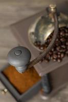 Molinillo de café antiguo con granos de café y café molido. foto