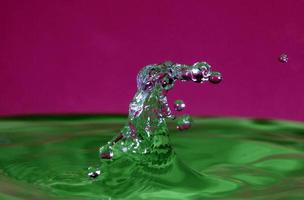 splash resulting from the impact of a drop with a container full of water photo