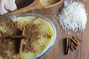 rice pudding with cinnamon in glass container on wooden table, rice on the table photo