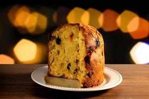 closeup panettone inside ceramic dish on wooden table, bokeh background with lights