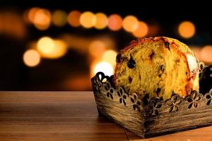 closeup panettone inside box on wooden table, bokeh background with lights