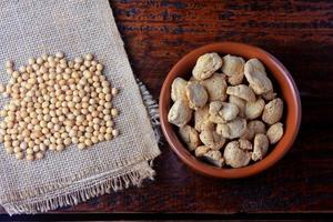 Soybeans meat, chunks in a brown ceramic bowl. Raw soybeans chunks on rustic wooden background photo