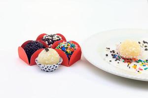 brigadeiro, brigadier, sweet chocolate typical of Brazilian cuisine covered with particles, in a wooden background. photo