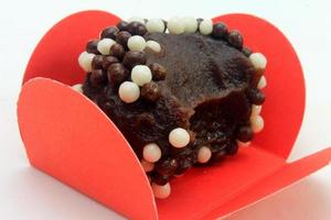 brigadeiro, brigadier, sweet chocolate typical of Brazilian cuisine covered with particles, in a wooden background. photo