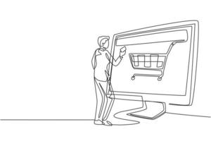 Continuous one line drawing young man shopping online via giant computer screen with shopping cart inside. Digital lifestyle, consumerism concept. Single line draw design vector graphic illustration