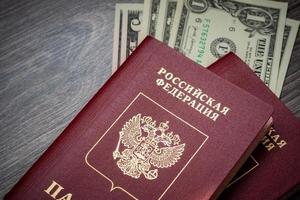 A foreign passport and dollars on a wooden background. photo