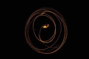 Círculo abstracto rastro de luz dorada espiral brillante efecto de luz elegante en un negro. foto