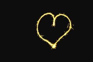 abstract heart gold sparkler overlays texture elegant surface pattern on black. photo