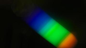 colorful blue and yellow and green light overlay refraction texture diagonal natural holographic on black. photo