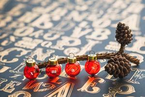 Christams gold pine conre and red glass ball decoration on vintage type pattern table. photo