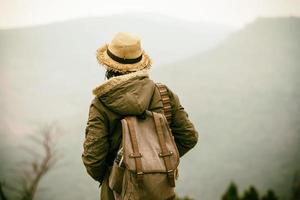 Young Hipster woman traveling in mountain with backpack enjoying sunrise photo