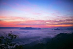 niebla del crepúsculo del paisaje en el amanecer de un paso de alta montaña al río mekong entre tailandés - laos. foto