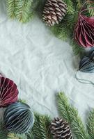 Spruce twigs with paper decorations on the green linen crumpled textile background photo