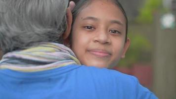 lächelnder weiblicher Teenager, der ihren Großvater glücklich zu Hause umarmt. video