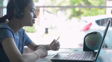 écolière parlant à un tuteur à distance avec appel vidéo sur ordinateur portable pendant l'étude de la leçon en ligne à la maison. video