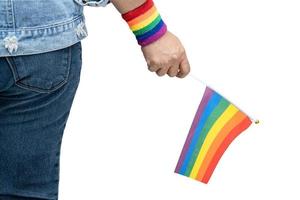 dama asiática con chaqueta de mezclilla azul o camisa de mezclilla y sosteniendo la bandera del color del arco iris, símbolo del mes del orgullo lgbt celebra anualmente en junio las redes sociales de gays, lesbianas, bisexuales, transgénero, derechos humanos. foto