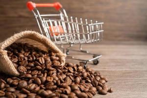 Box with shopping cart on coffee beans, Import Export Shopping online or eCommerce delivery service store product shipping, trade, supplier concept. photo