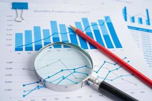 Magnifying glass on charts graphs paper. Financial development, Banking Account, Statistics, Investment Analytic research data economy, Stock exchange trading, Business office company meeting concept. photo