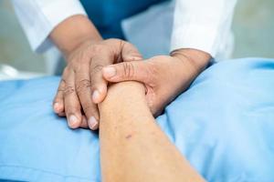 médico sosteniendo las manos conmovedoras anciana asiática o anciana paciente con amor, cuidado, ayuda, aliento y empatía en la sala del hospital de enfermería, concepto médico saludable