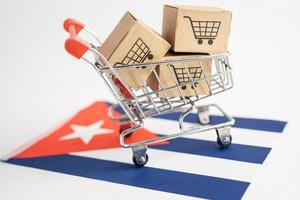 Caja con logotipo de carrito de compras y bandera de Cuba, importación, exportación, compras en línea o comercio electrónico, servicio de entrega de finanzas, tienda, envío de productos, comercio, concepto de proveedor. foto
