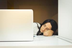 tired female employee in office sleeps photo