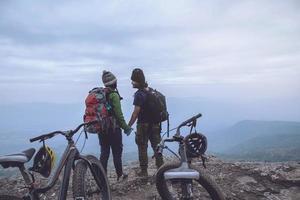 Asian lover women and men Travel Nature. Travel relax ride a bike Wilderness in the wild. Standing on a rocky cliff. Thailand photo