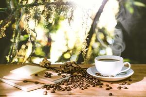Taza de la mañana de café expreso y granos de café, el desenfoque de la naturaleza de fondo foto