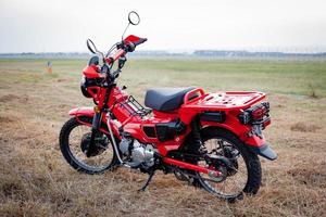 Motocicleta estacionada en el césped junto al aeropuerto de Tailandia foto