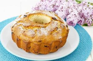 Delicious homemade raisin cupcake, lilac flowering branch. photo