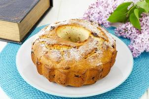 Delicious homemade raisin cupcake, lilac flowering branch. photo