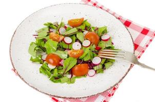 Healthy nutrition. light salad of beetroot leaves, radish and cherry tomatoes photo