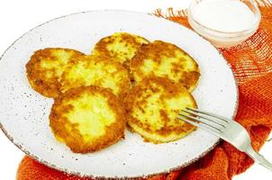 Vegetable marrow pancakes with white sauce. Photo