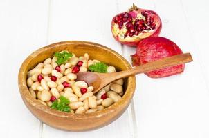 Dish with white beans and pomegranate seeds. photo