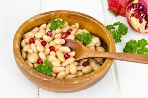 Dish with white beans and pomegranate seeds. photo