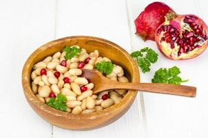 Dish with white beans and pomegranate seeds. photo