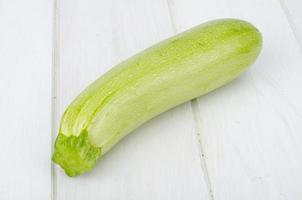 Green young fresh zucchini on wooden table for cooking photo