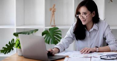 retrato mujer asiática que trabaja con la computadora portátil. foto