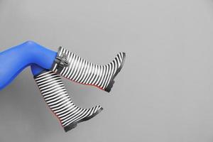 Legs of beautiful woman in stylish gumboots on color background photo