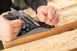 Carpenter working with smoothing plane, closeup photo