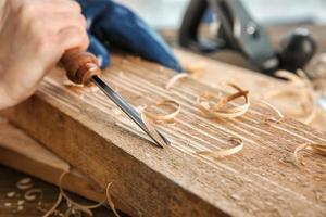 Carpenter working with chisel, closeup photo