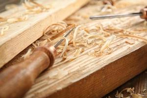Cincel, tablas de madera y aserrín en el taller de carpintería