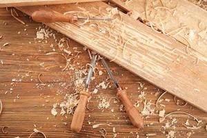 Chisels, wooden boards and sawdust in carpenter's workshop photo