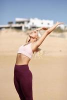 mujer rubia caucásica practicando yoga en la playa foto