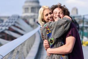 feliz pareja abrazándose por el puente del milenio, el río támesis, londres. foto