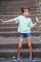 Nine-year-old girl dancing on the steps outdoors photo