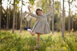 Little girl in nature field wearing beautiful dress photo