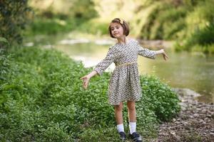 Little girl in nature stream wearing beautiful dress photo