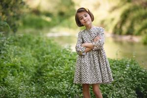 Little girl in nature stream wearing beautiful dress photo