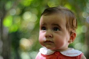 Six months old baby girl having fun outdoors. photo